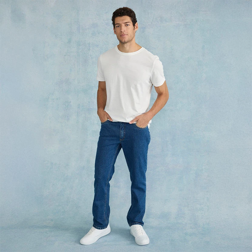 Wit T-shirt, blauwe regular fit jeans en witte sneakers.