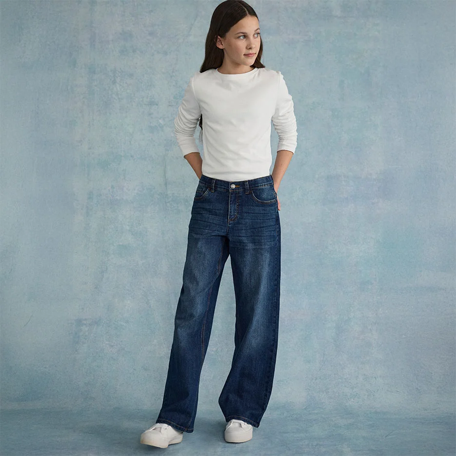 Witte, gestructureerde top gecombineerd met een wijde jeans en witte sneakers.