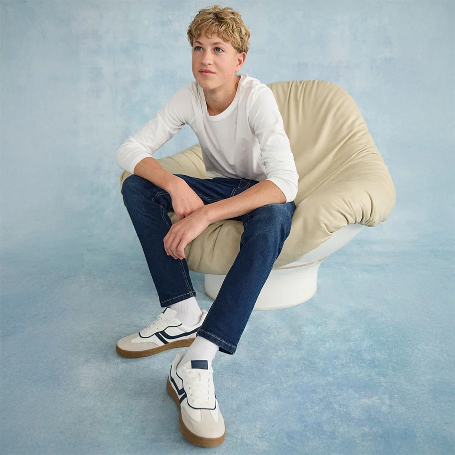 Casual look met een wit shirt met lange mouwen, een klassieke jeans en witte sneakers.