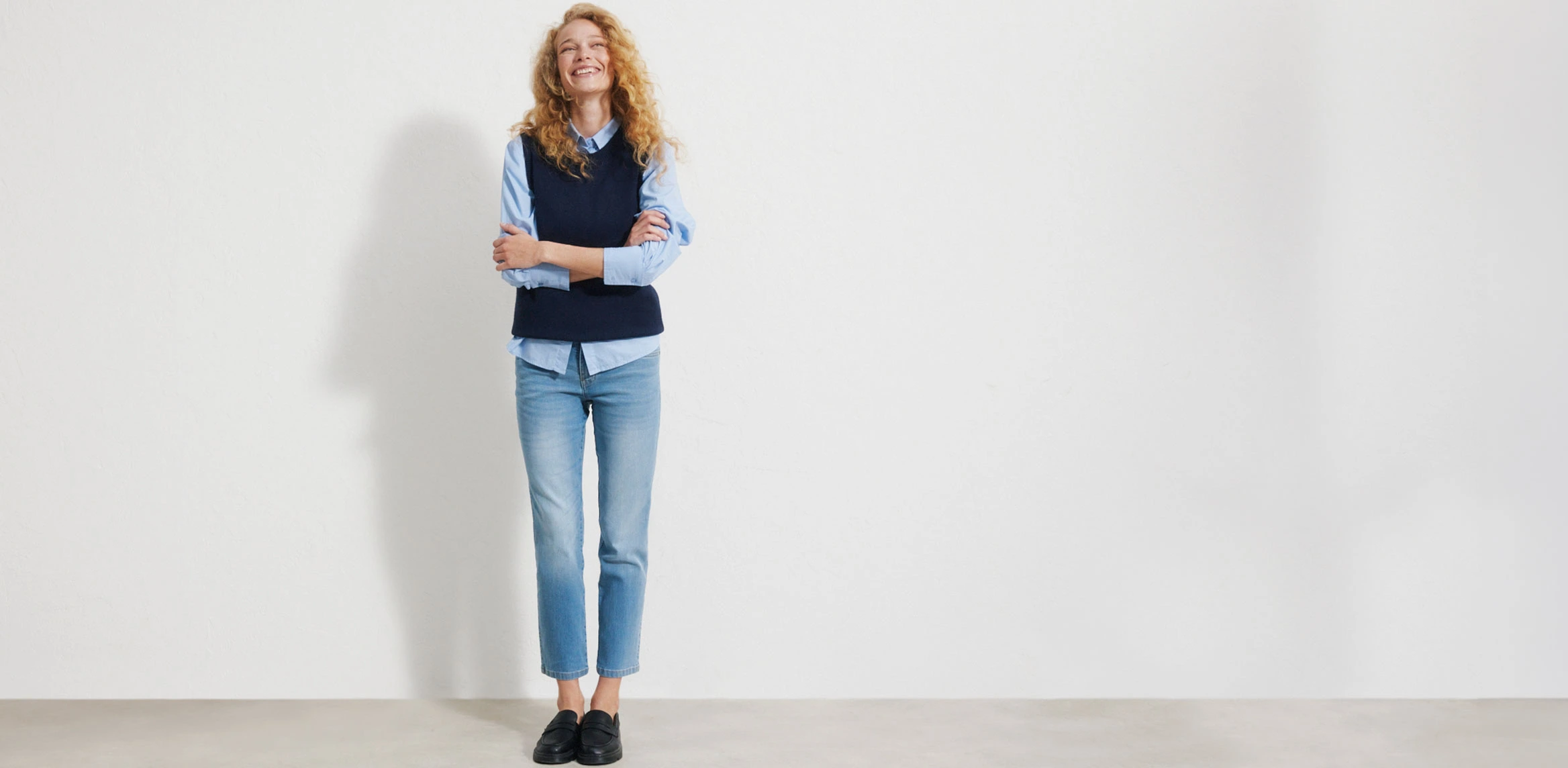"Lichtblauwe Straight‑Fit jeans met een hoge taille en een rechte, klassieke pijp, gemaakt van glad, licht verweerd denim, gecombineerd met een wit T‑shirt, een denimjas en bruine schoenen."