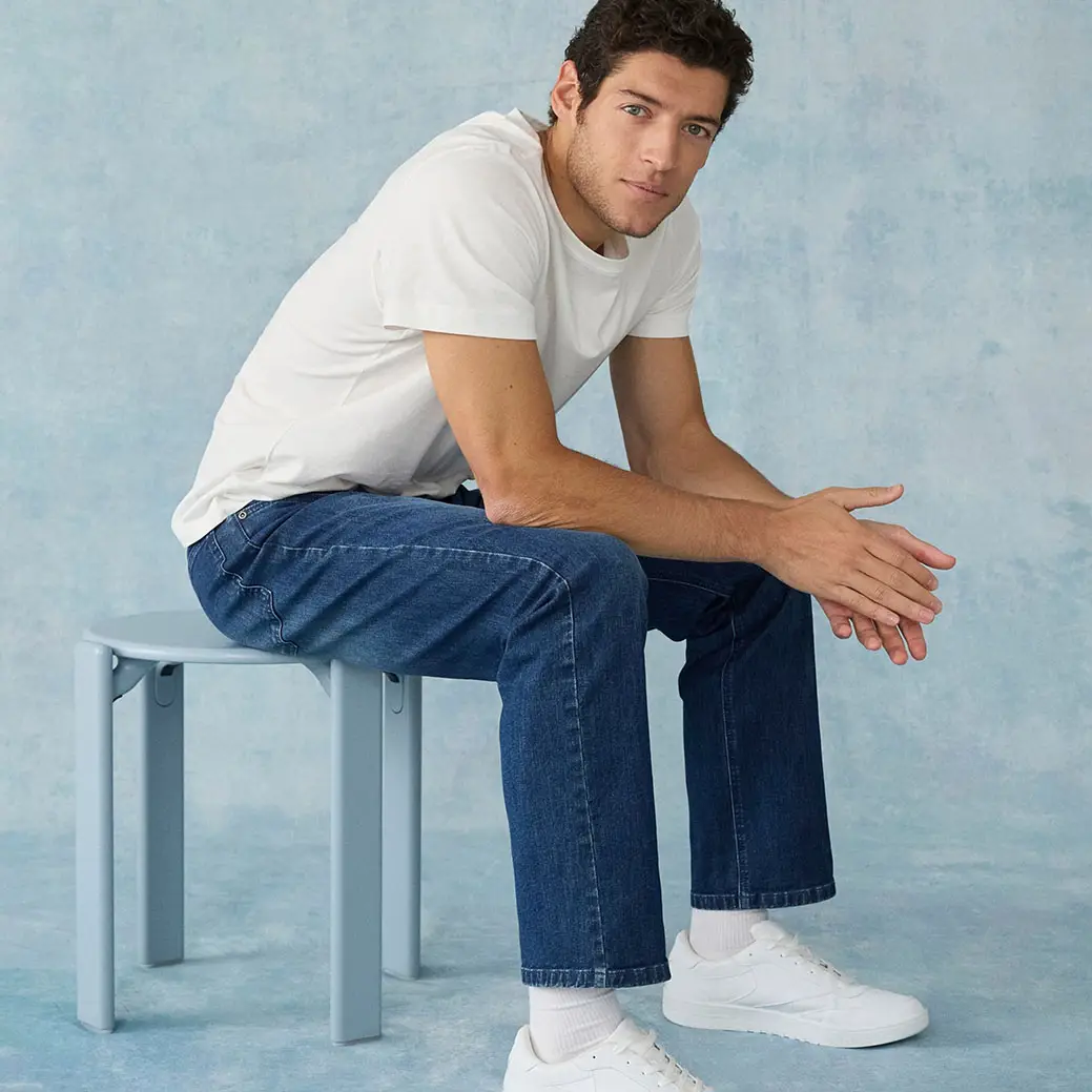 Casual look met wit T-shirt en blauwe jeans.