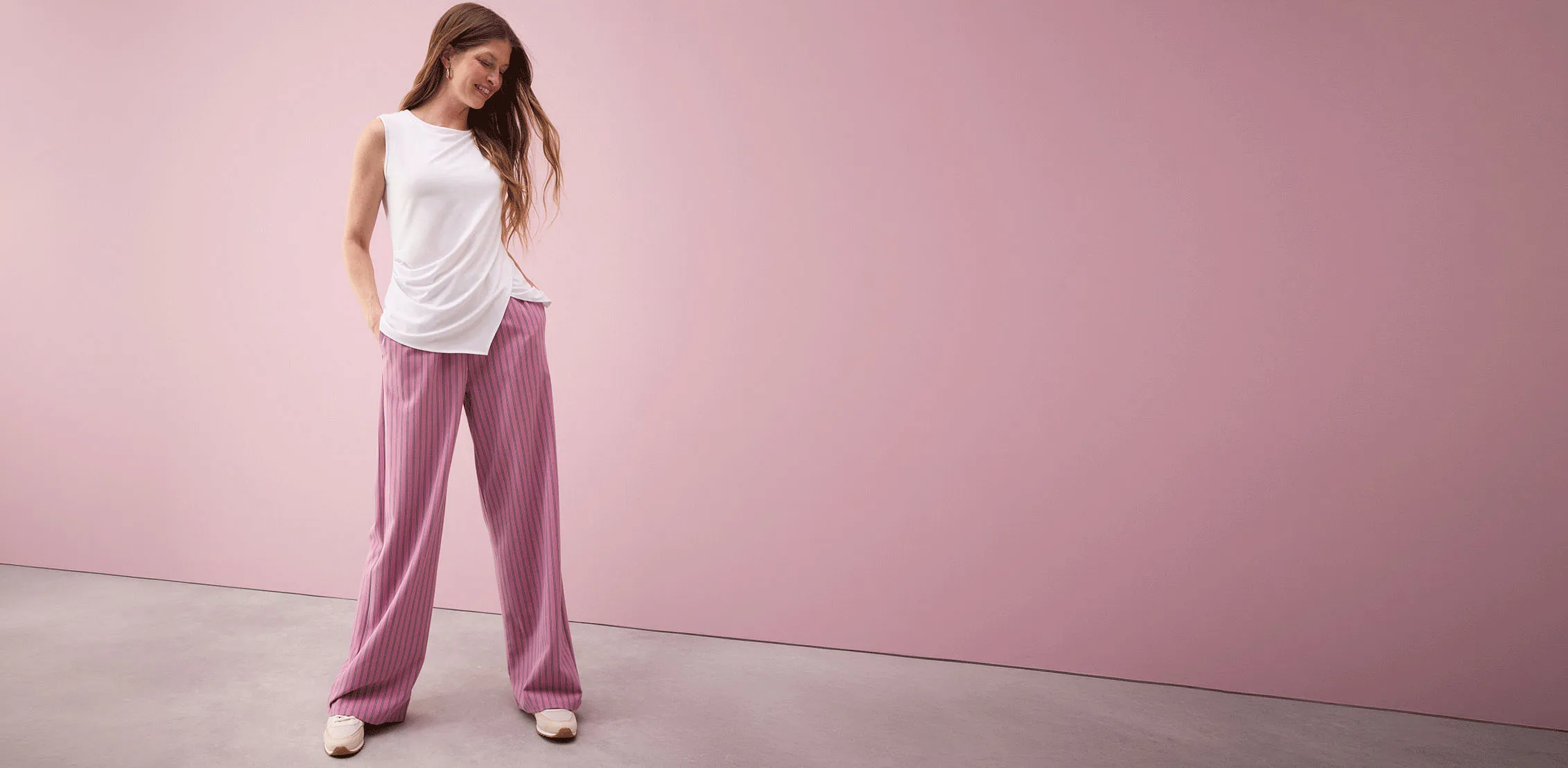 Witte mouwloze top gecombineerd met roze gestreepte palazzo broek.