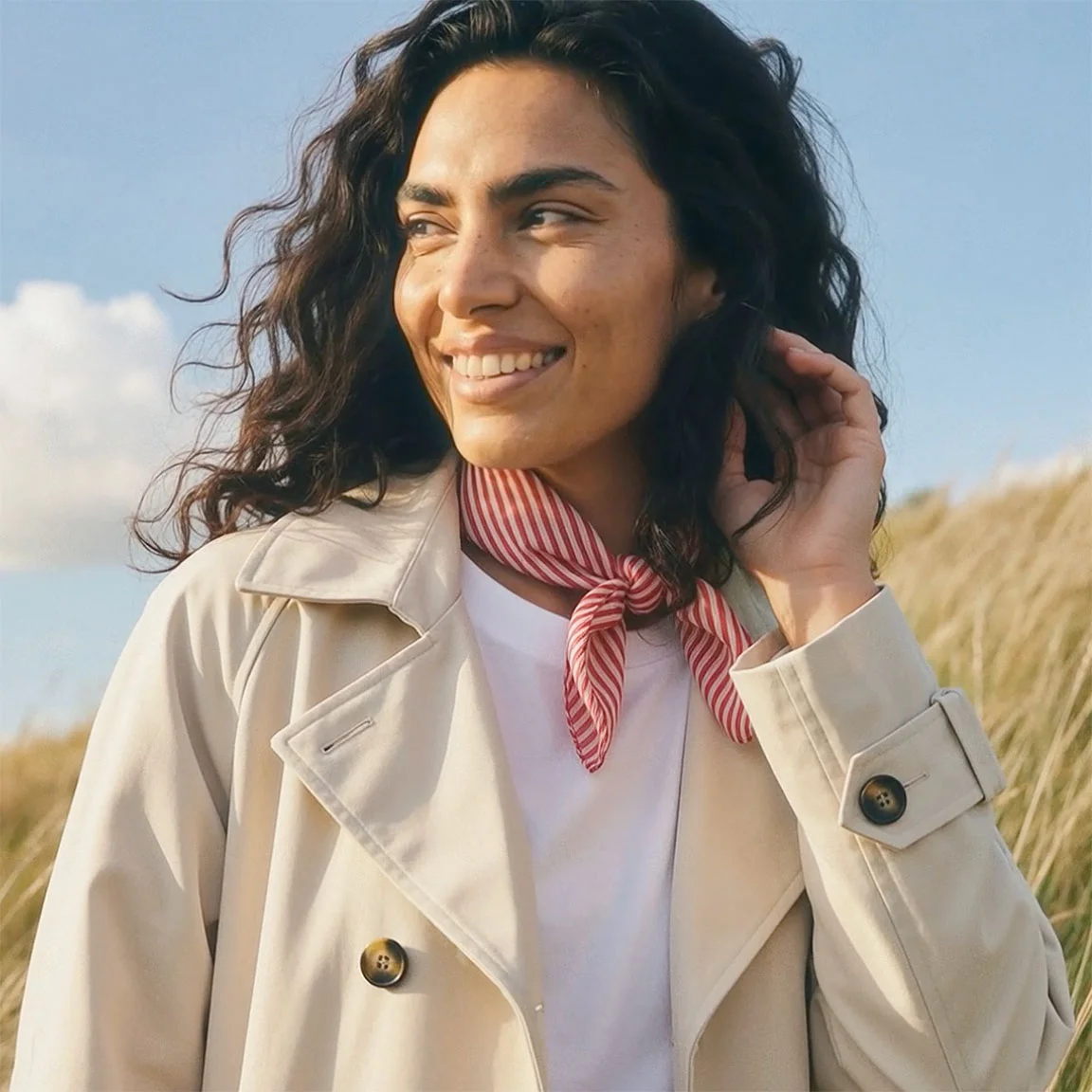 Beige trenchcoat met licht shirt eronder.