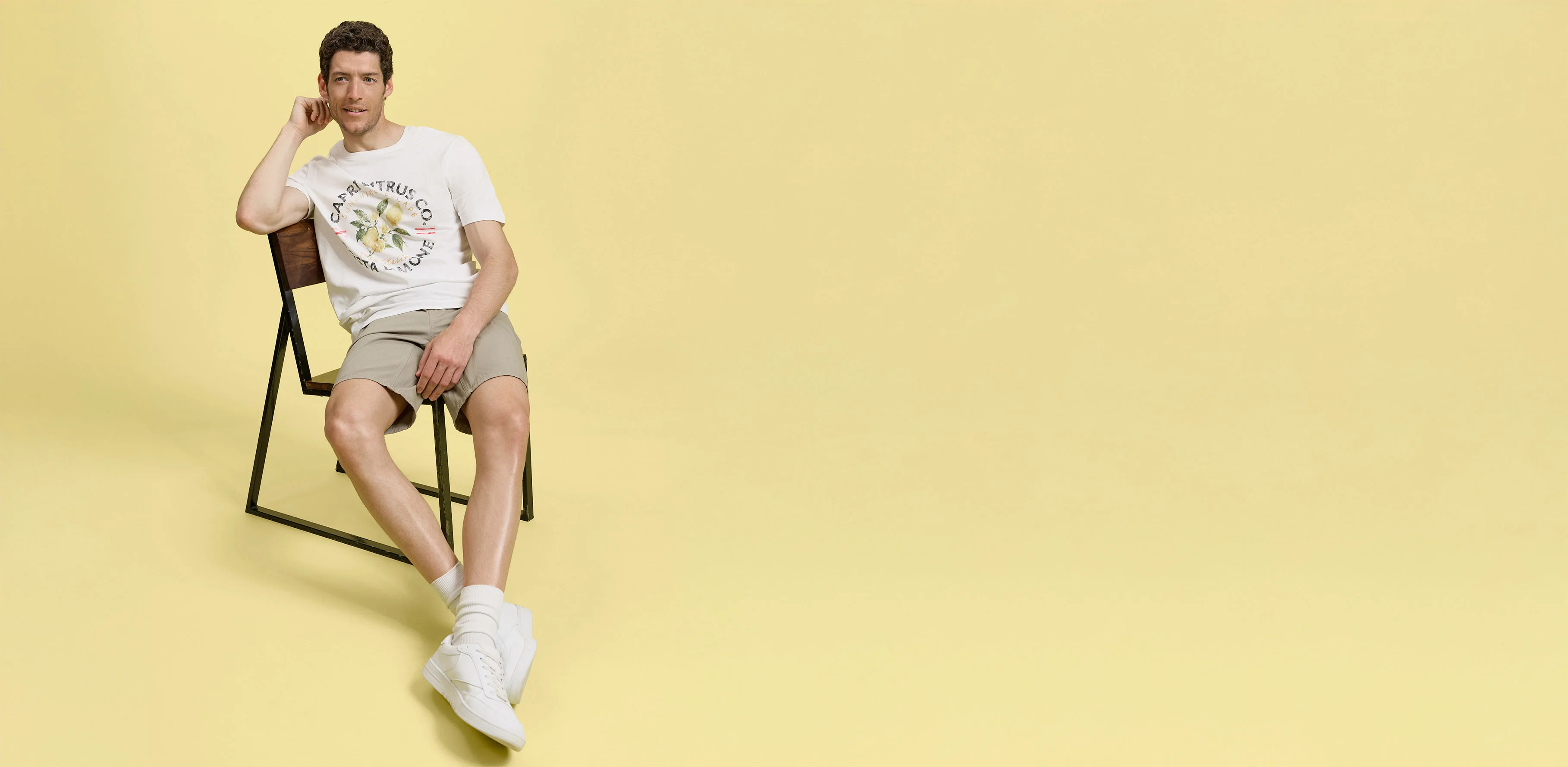 Zomerlook met beige short, wit T-shirt en comfortabele sneakers.